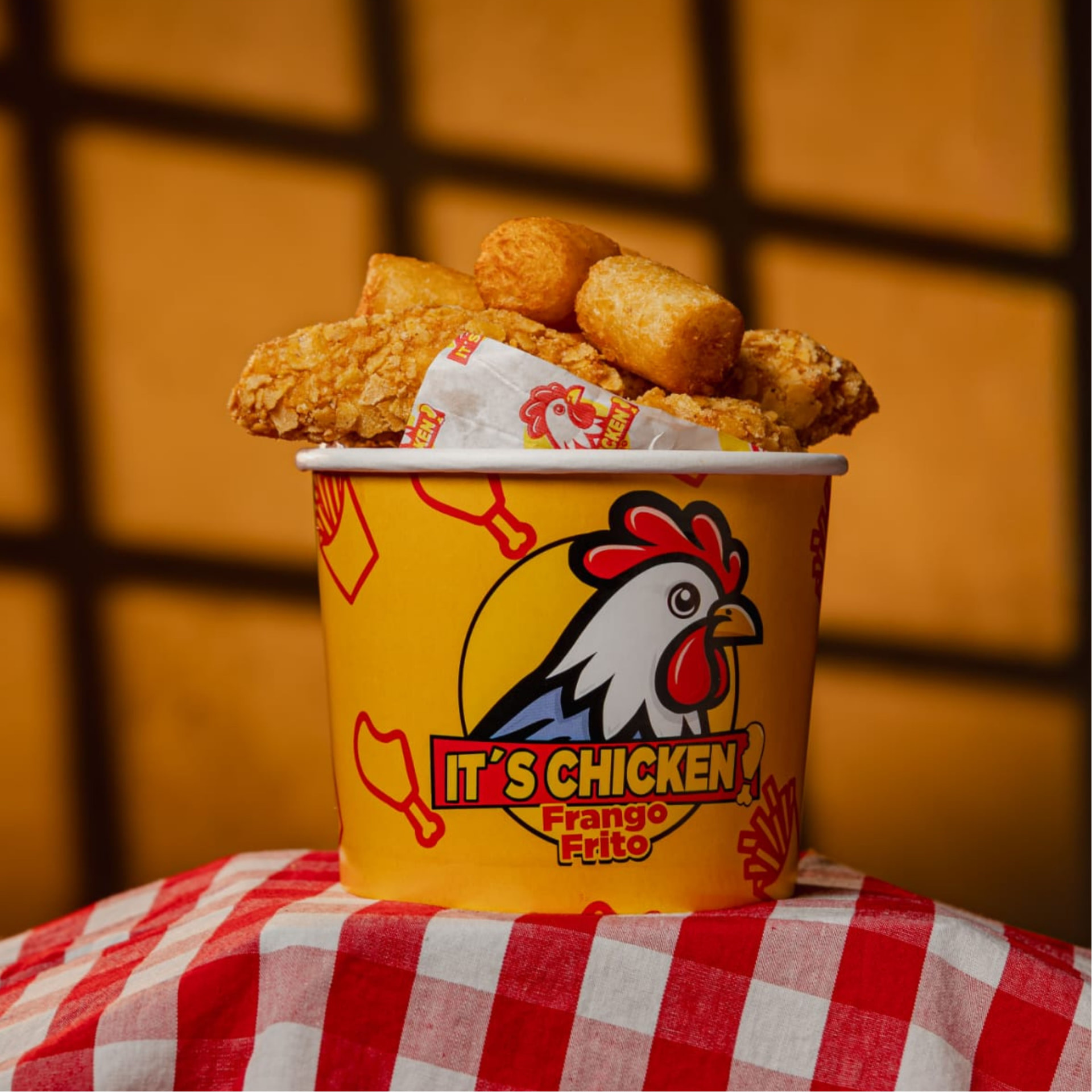 Balde amarelo da It's Chicken com frango frito crocante e batata frita